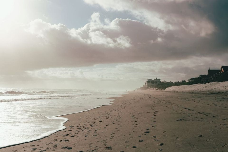 Florida beachfront homes on a dune under overcast sky