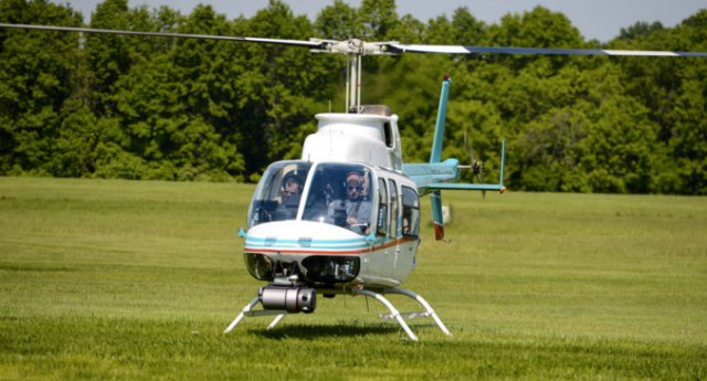 Pilots supervise a Bell 206 helicopter during tests of the attached Autonomous Aerial Cargo/Utility System in Bealeton, Virginia, May 25, 2016. Pilots make sure that the system can run smoothly and perform maneuvers the same way a human controlling it would.