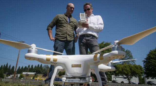 David Famolari (left) of Verizon Ventures and Jonathan Evans conduct a pre­flight check and analyze airspace using the Skyward drone airspace map before flying at a local Portland park for drone hobbyists.