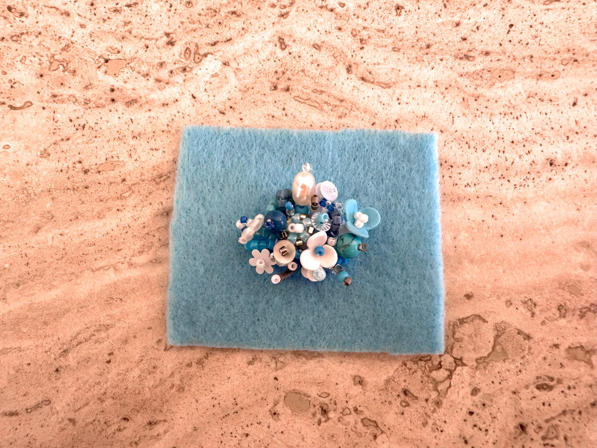 A piece of felt with 3D-beaded composition. Front side