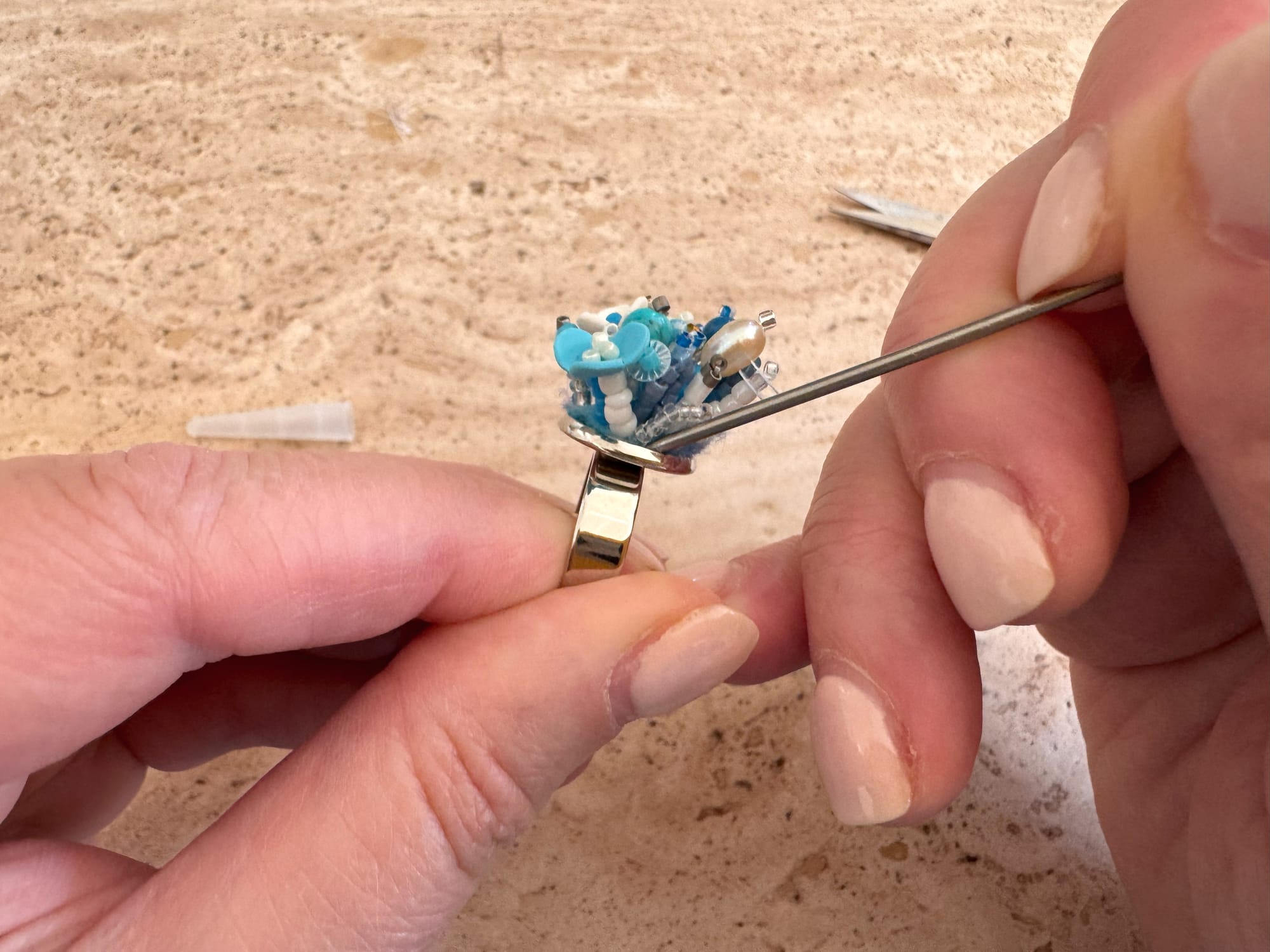 Inserting the felt into the ring setting using an awl