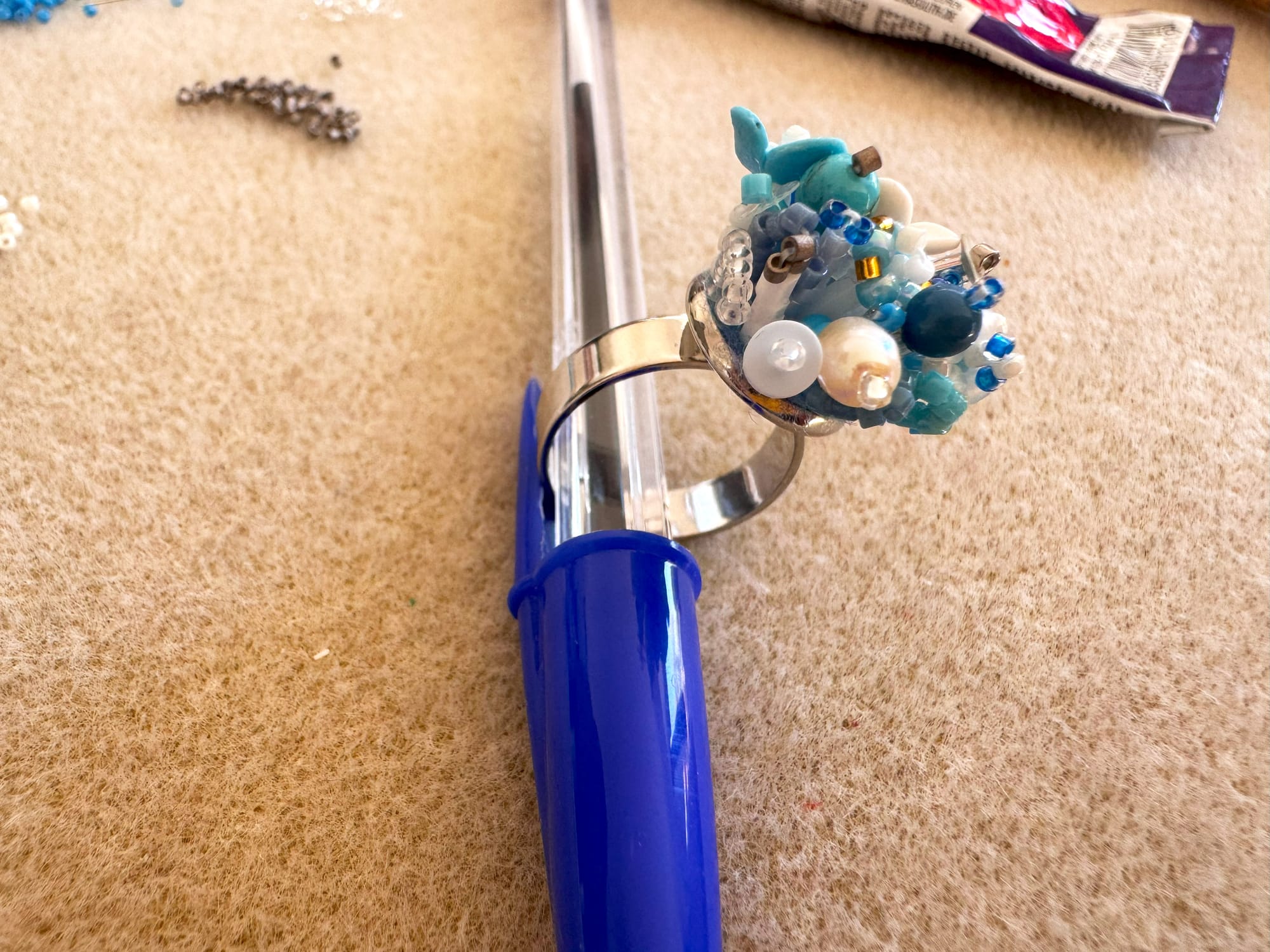 The ring is inserted into the cap of a pen for drying