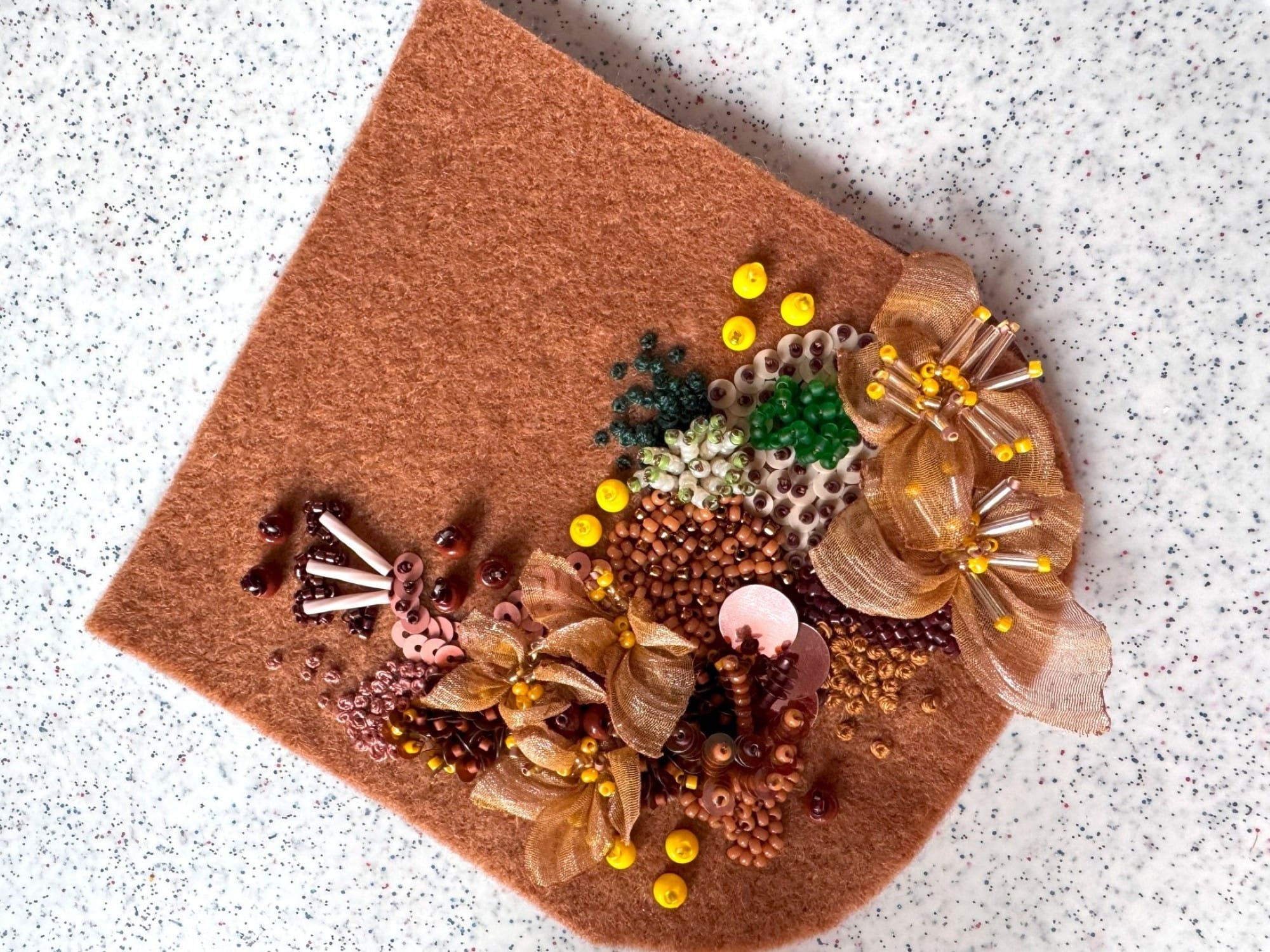 The felt detail is glued to the faux leather detail