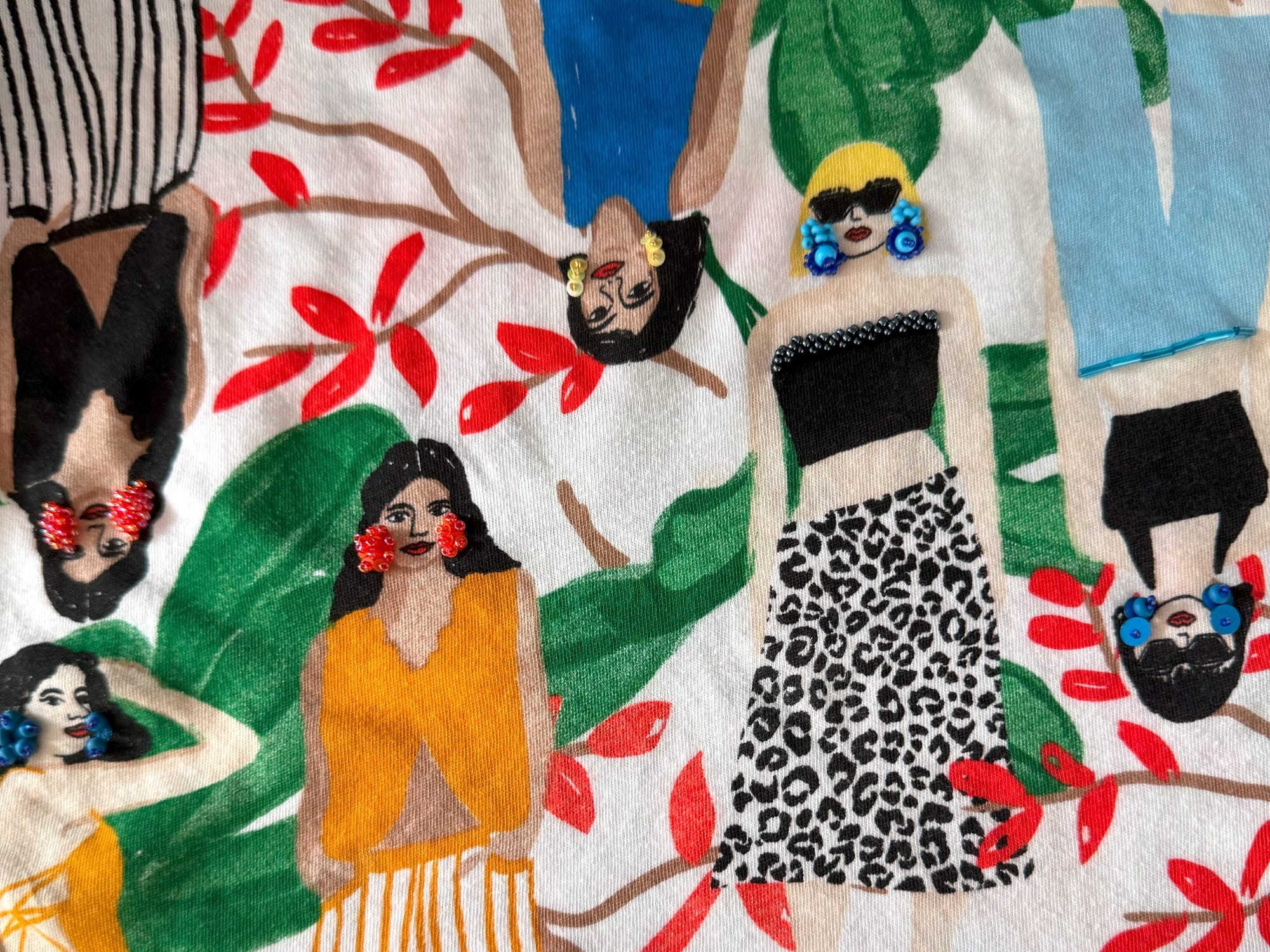 Fragment of the t-shirt embellished with embroidery, sequins, and beads