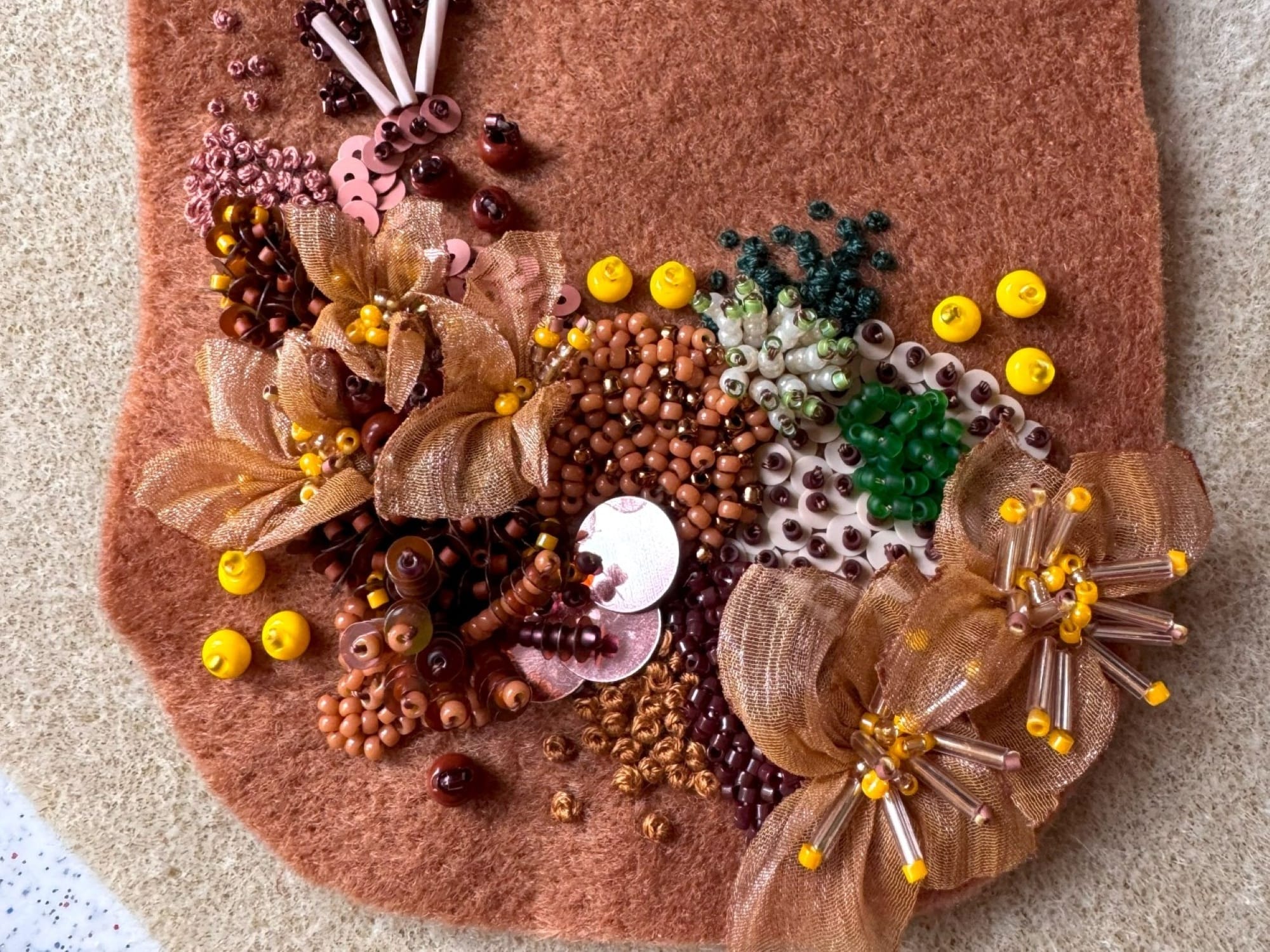 The felt detail is embellished with embroidery, beads, and sequins