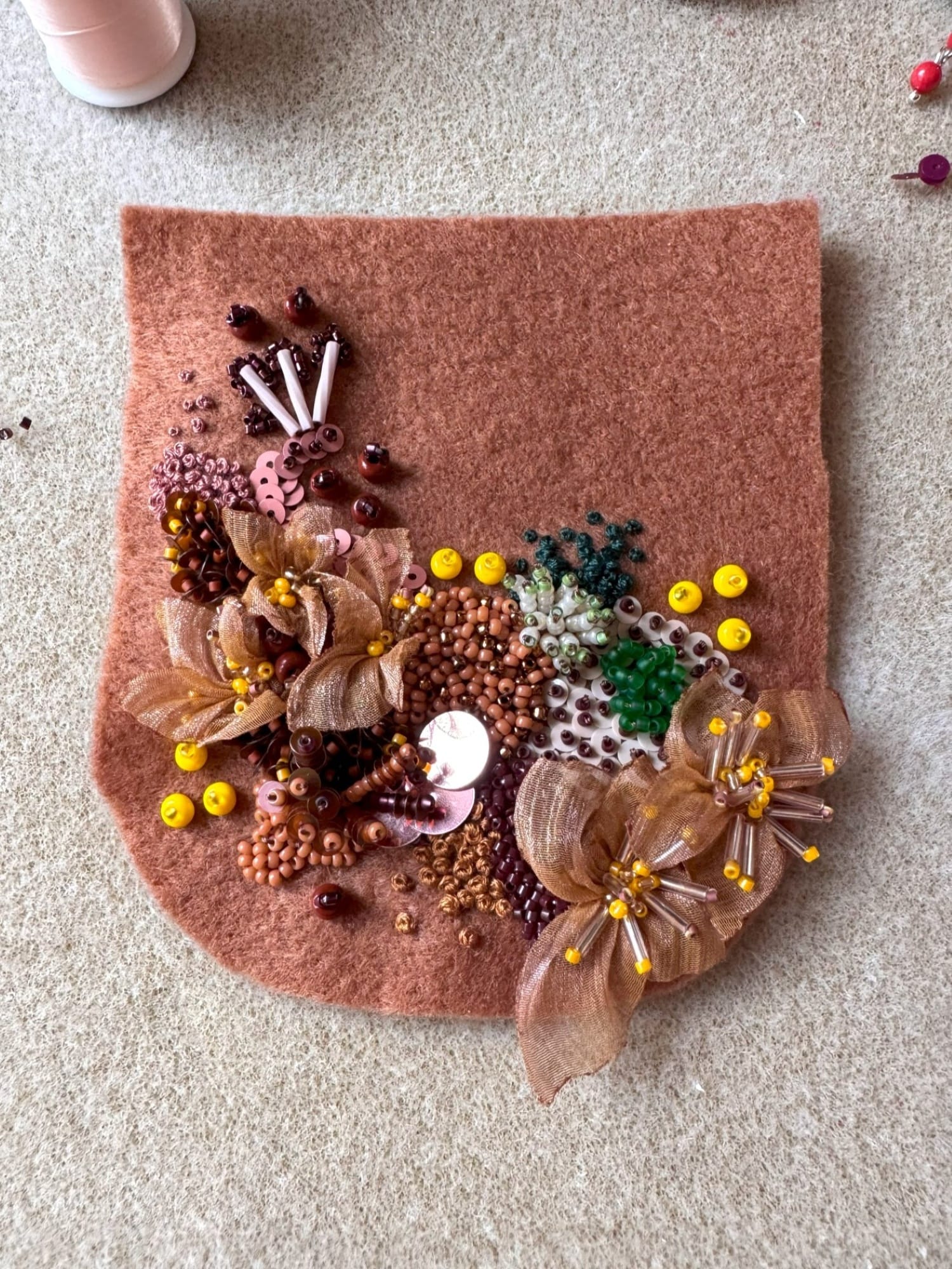 The felt detail is embellished with embroidery, beads, and sequins