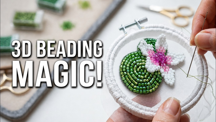 A finished 3D beaded water lily with green padded lily pads and a pink-and-white flower held in an embroidery hoop.