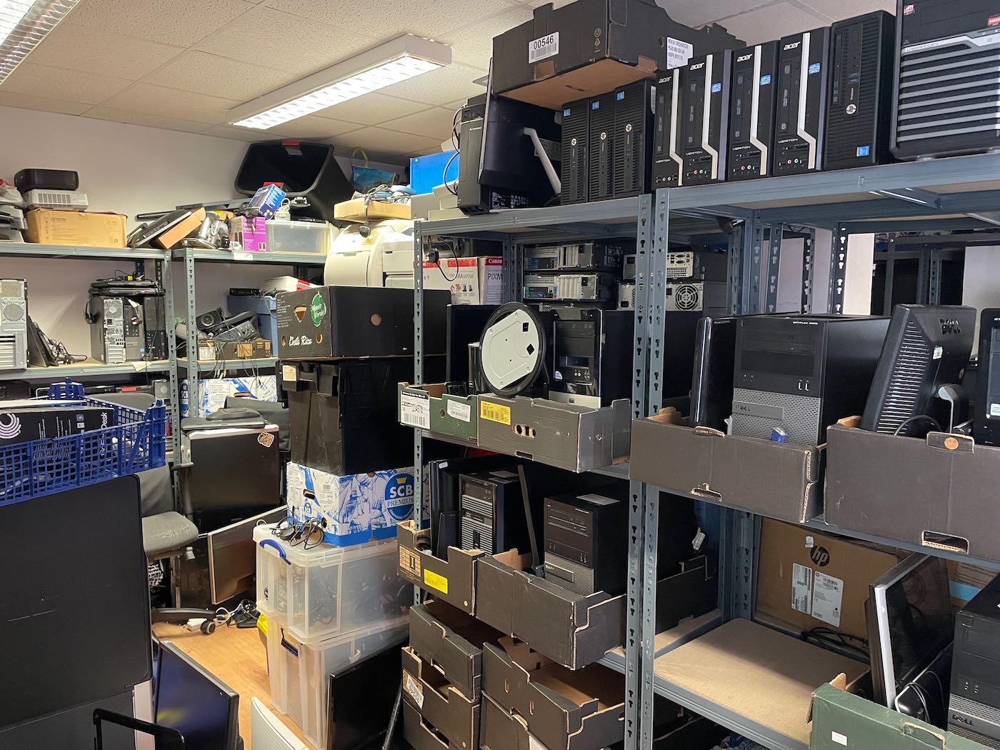 Computer equipment stacked on shelves ready to be donated