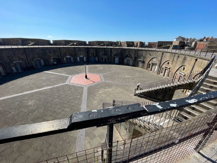 View down into a circular parade ground of a fortress with a deep blue sky