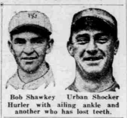 A grainy, vintage black-and-white newspaper clipping from May 1926 showing the headshots of two baseball players. On the left is pitcher Bob Shawkey, looking forward with a serious expression and wearing a light-colored baseball cap with a stylized dark "NY" on the front. On the right is Urban Shocker, wearing a dark baseball cap and uniform, appearing to look straight ahead with a slight smirk. Printed directly beneath the photographs are their names, "Bob Shawkey" and "Urban Shocker," followed by the caption: "Hurler with ailing ankle and another who has lost teeth."