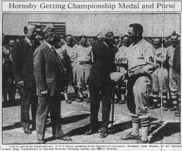 1926 photo of Rogers Hornsby receiving his NL MVP medal and cash award from John Heydler and Kenesaw Mountain Landis before a Cardinals-Phillies game at Sportsmans Park.