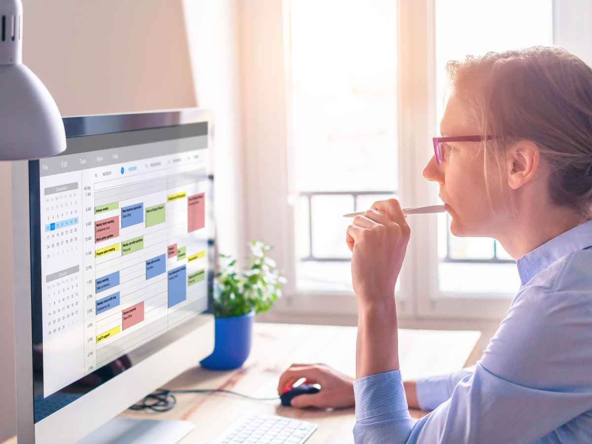 A woman looks at her time blocking schedule to plan her week.