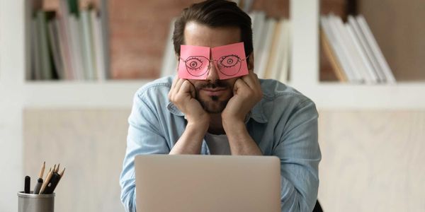 Sleep-deprived exhausted man covers his eyes with mock-up eyes.