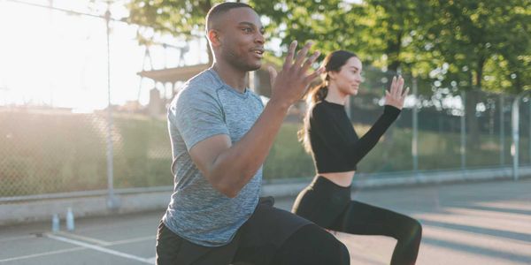 Two friends stretching at the start of their exercise routine.