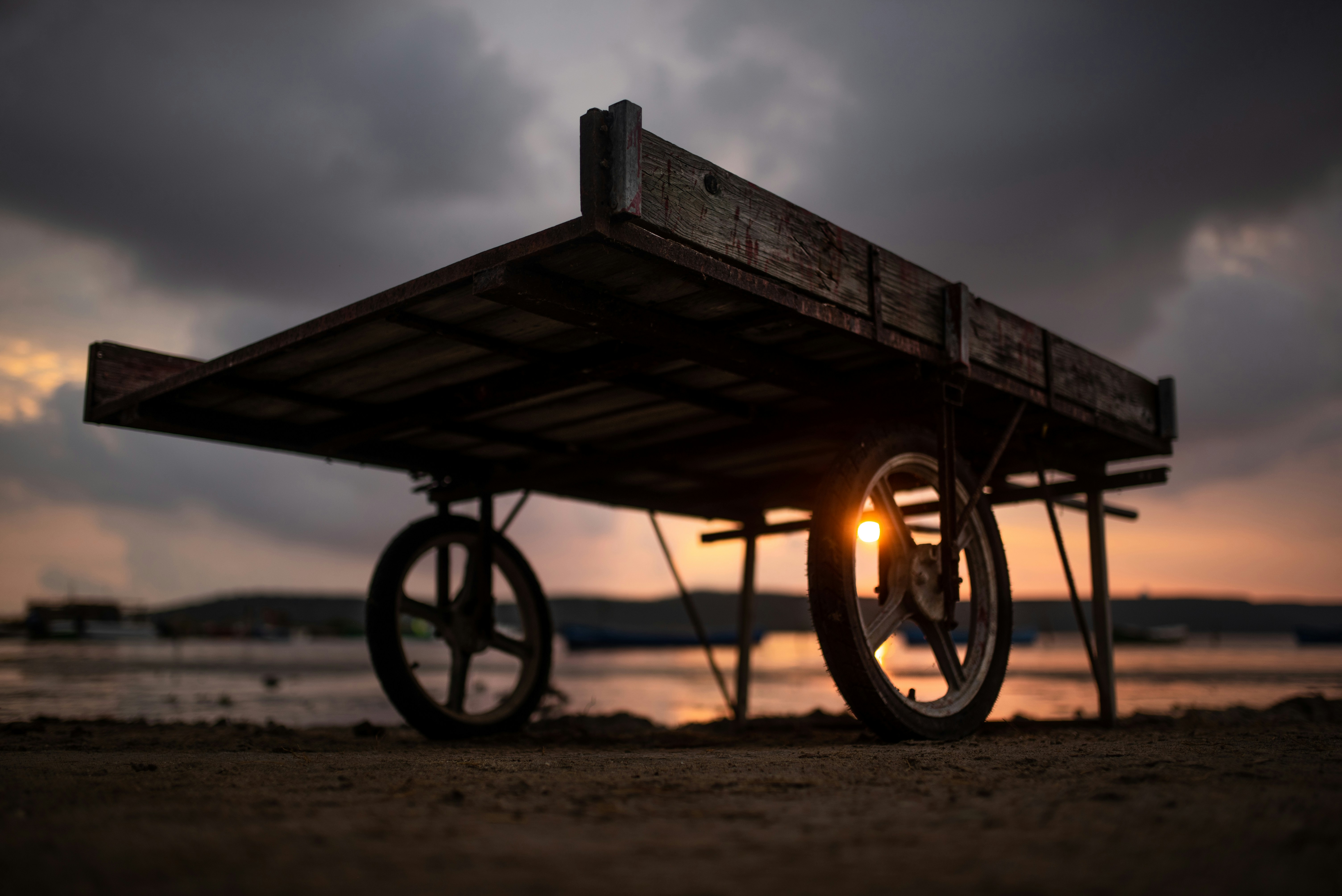 Unsplash image of a cart, just blocking a low sun in a dark sky.