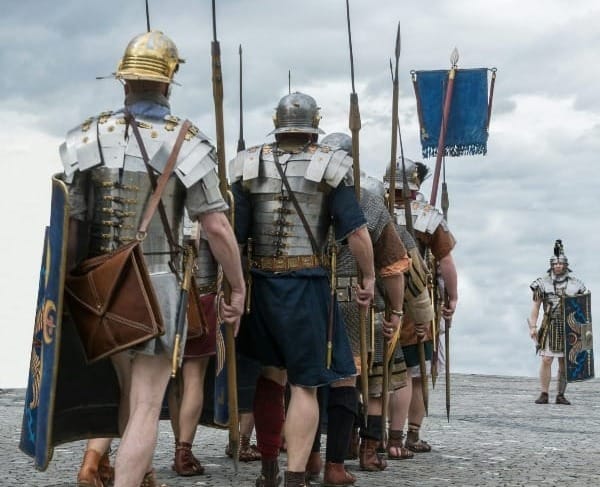 group of men in brown and green camouflage uniform standing on gray sand during daytime