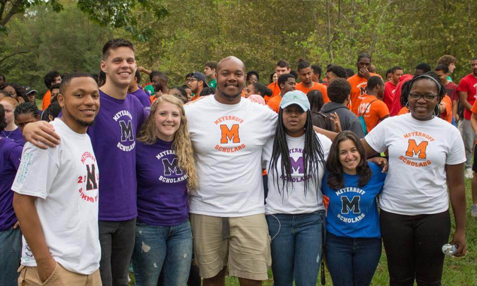 Photo of Meyerhoff Scholars at a "Family Meeting" donning branded t-shirts.