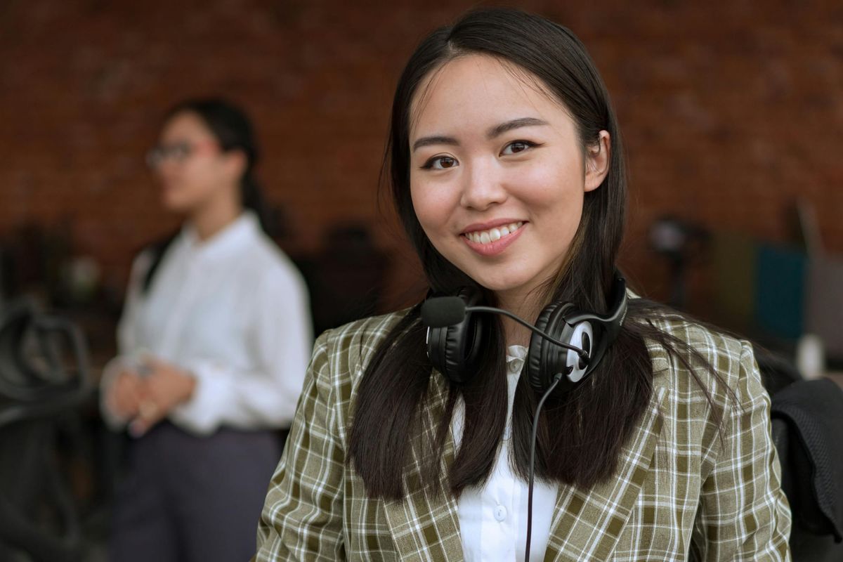 Smiling employee wearing headphones and microphone.
