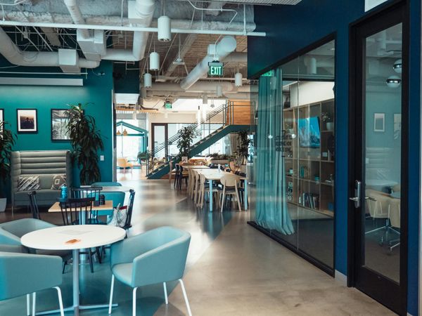 Office space with tables, chairs, meeting rooms, and lounge area.