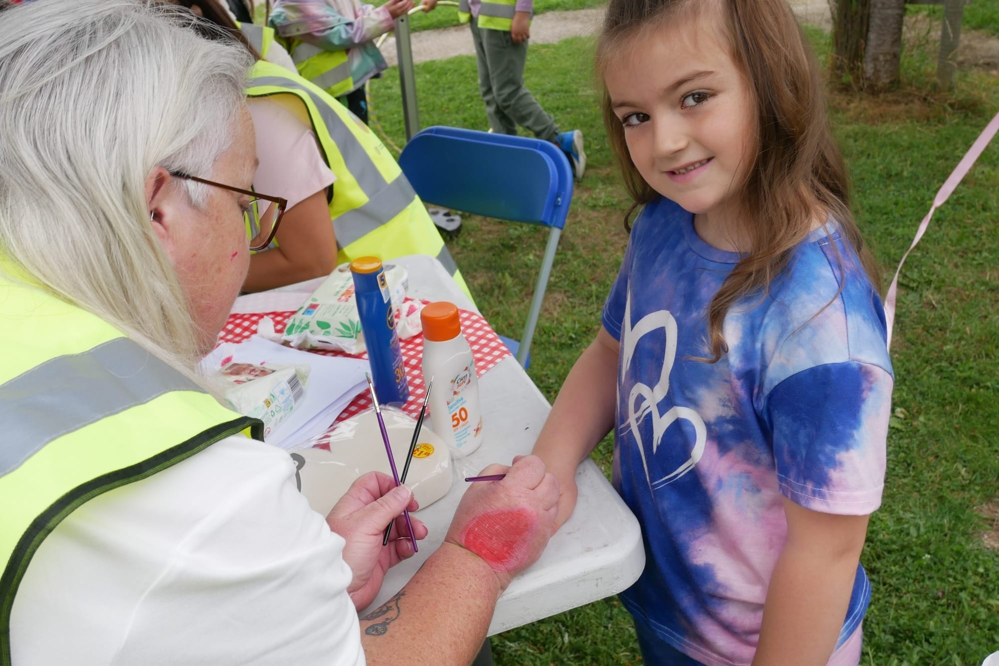 Kendall Byrne getting a strawberry painted on her hand. 