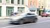 Cars blurred by motion on street.