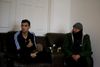 Mohamad Sadat Snunu and his father Mahmud sit on the couch at home. Photo by Shamim Malekmian.