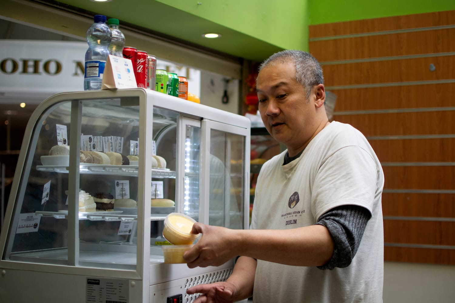 A man takes a pot out of a fridge.