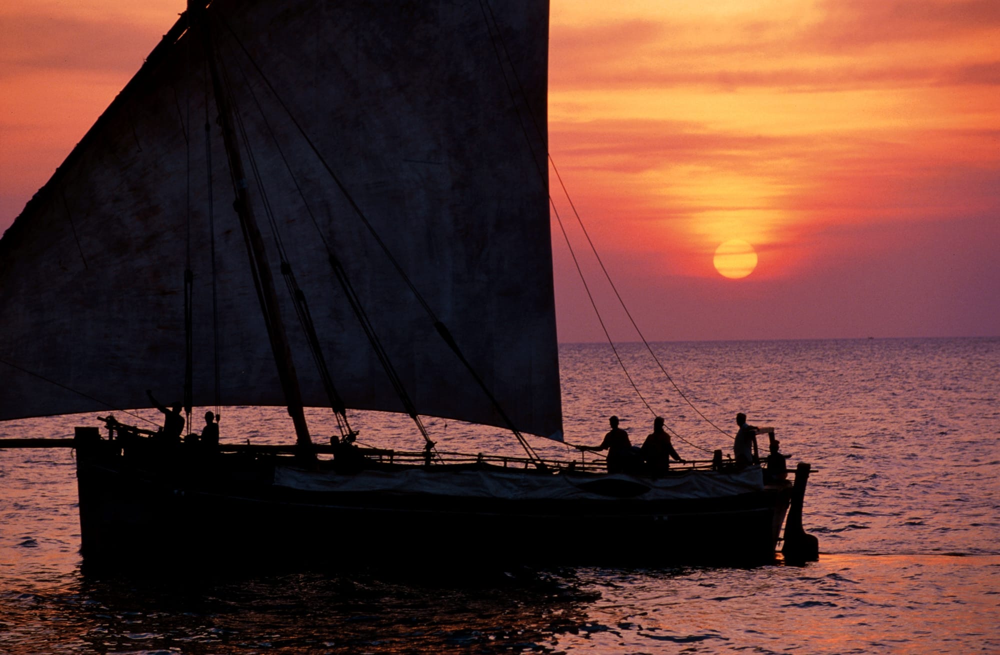 A traditional dhow sailing at sunset off the coast of Zanzibar