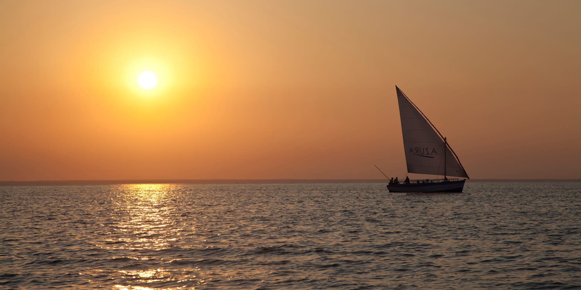 Dhow sailing at sunset in the Bazaruto Archipelago, Mozambique, on a luxury Mozambique beach holiday