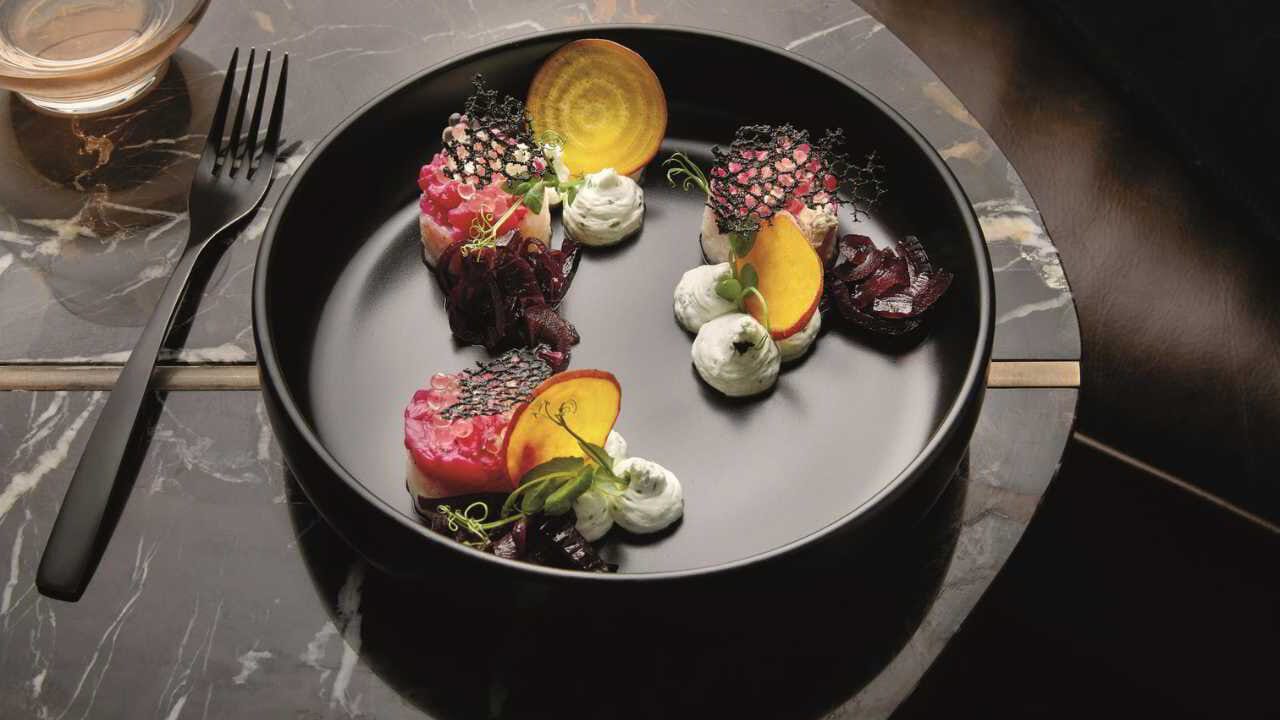 A plated tasting course at a private safari villa, served on a dark stone plate.
