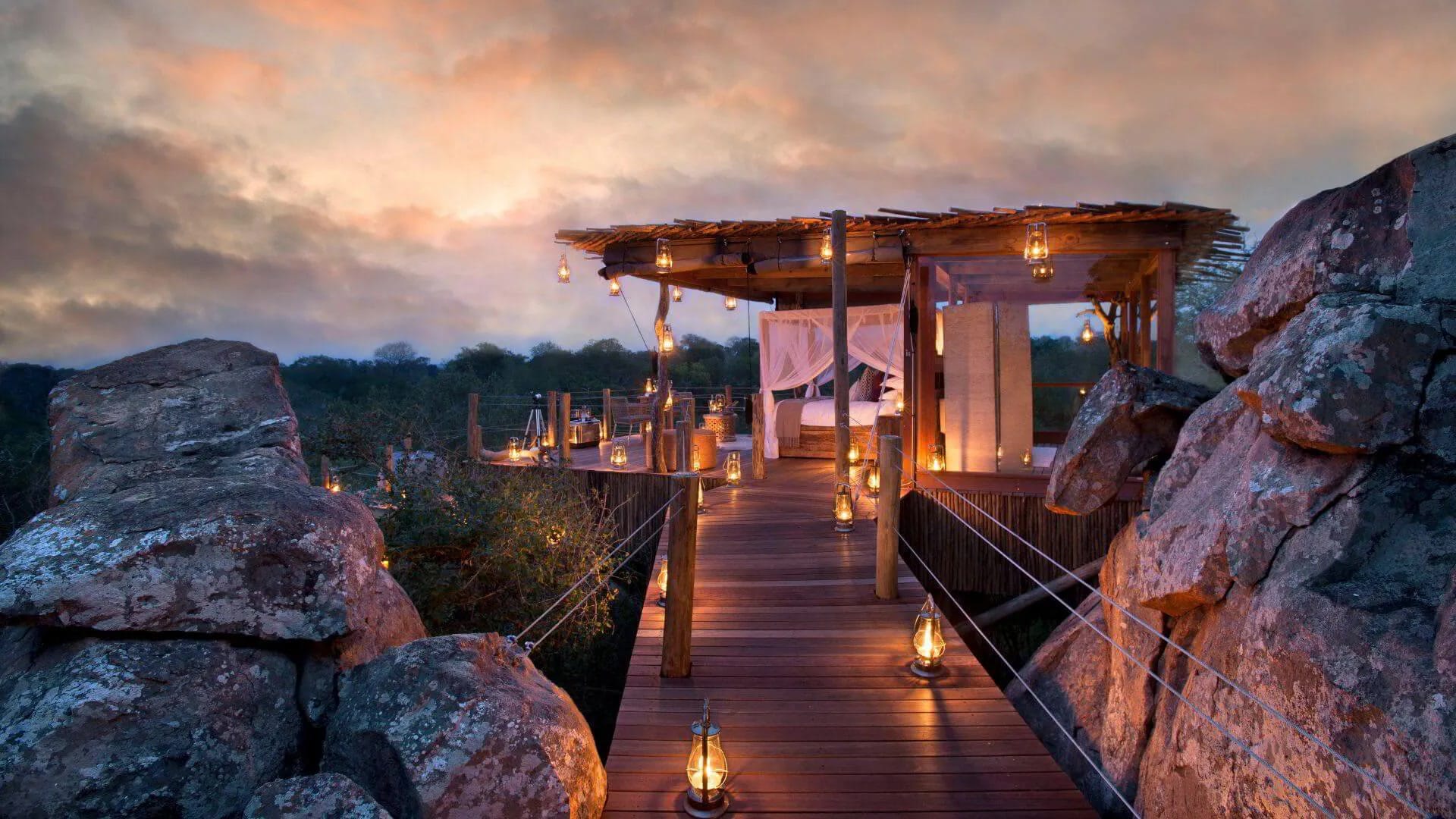 Treehouse suite in the Sabi Sand, lit at dusk above the Sabie River