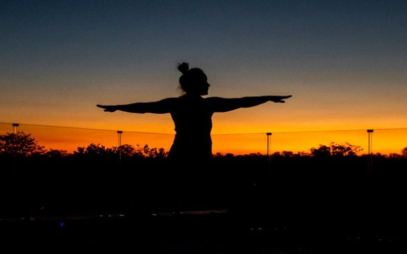 Yoga mat rolled out on a timber deck as the sun rises above the South African bushveld