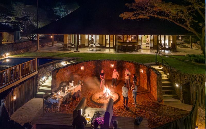 Safari lodge chef preparing a plant-based dish with fresh local produce in an outdoor kitchen
