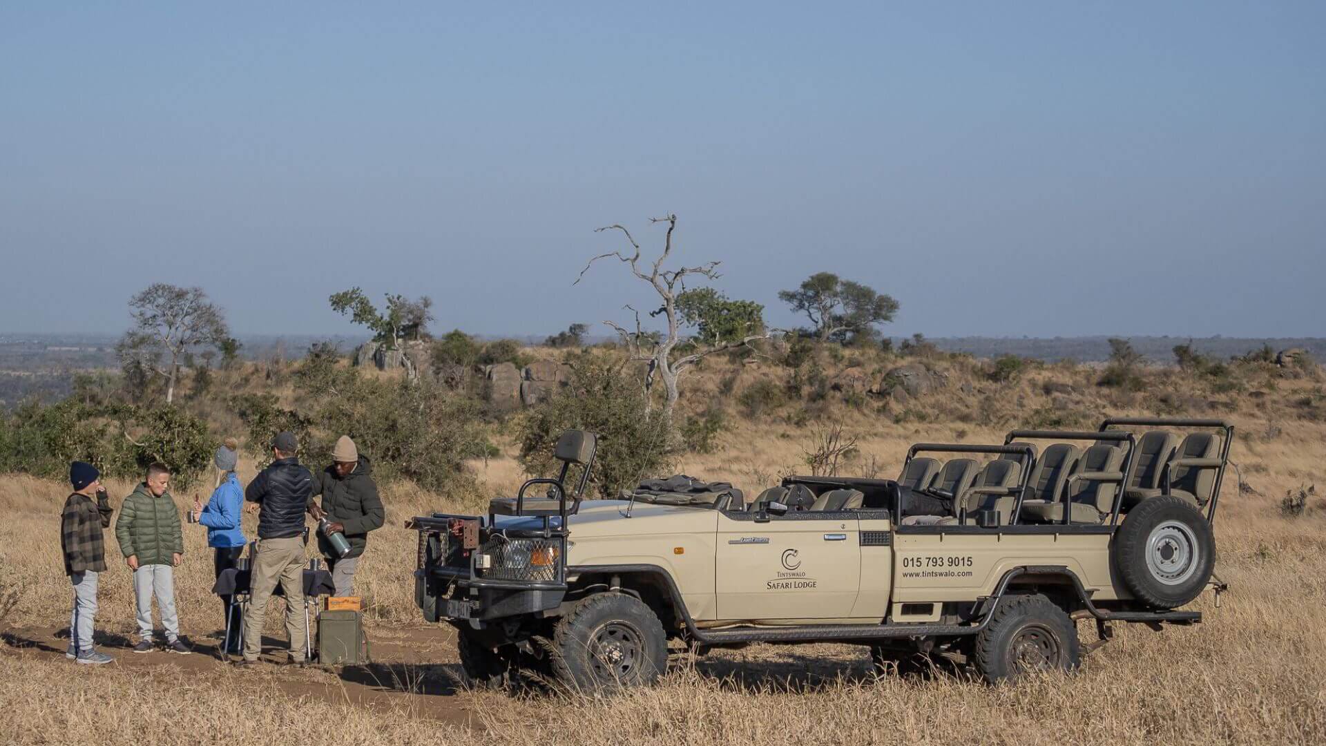 A family bush coffee stop with our young clients and their guide, vehicle parked, nobody else for miles