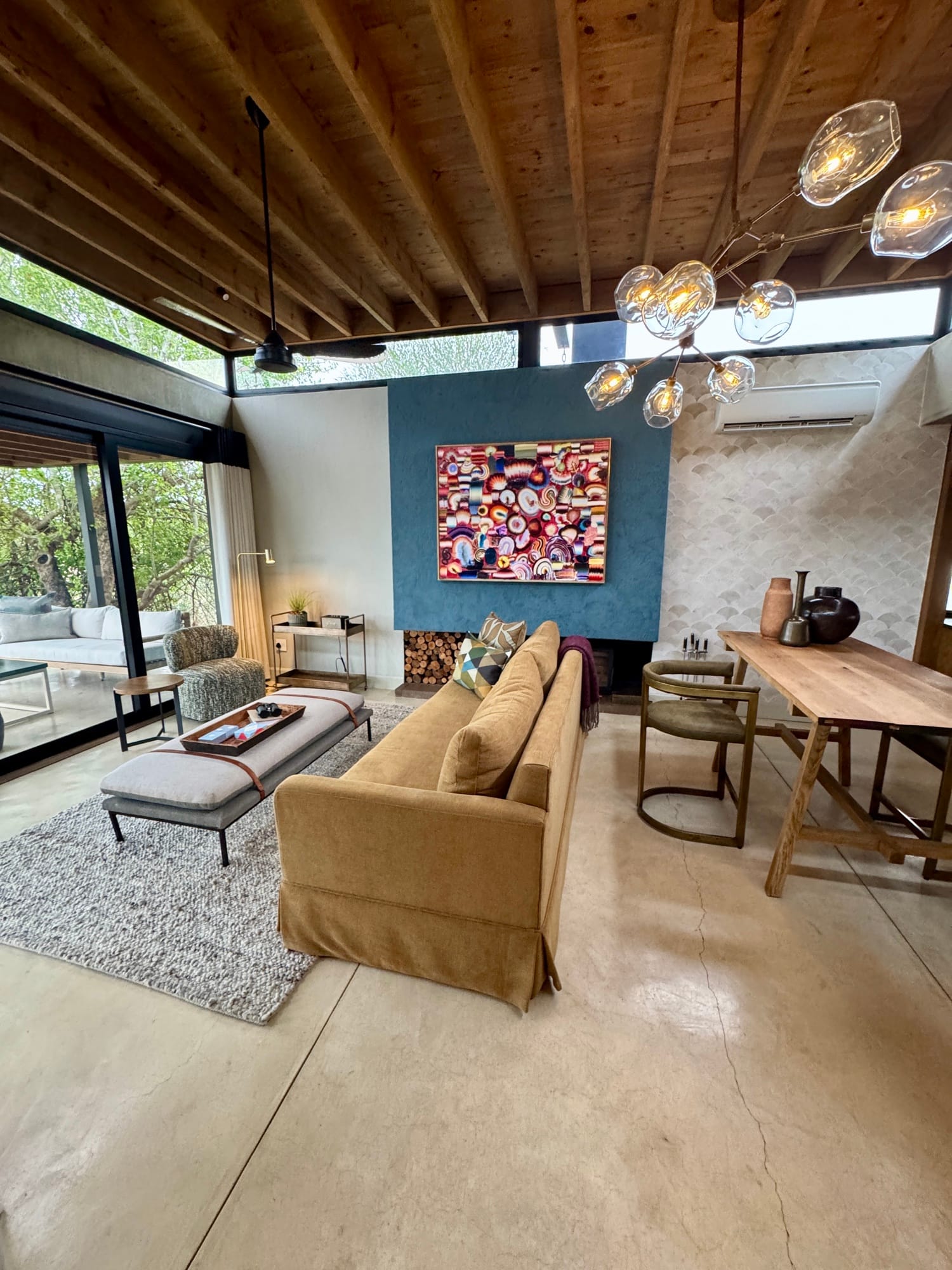 Lion Sands Ivory Lodge lounge with blue feature wall, red mosaic artwork, ochre sofa and blown-glass chandelier