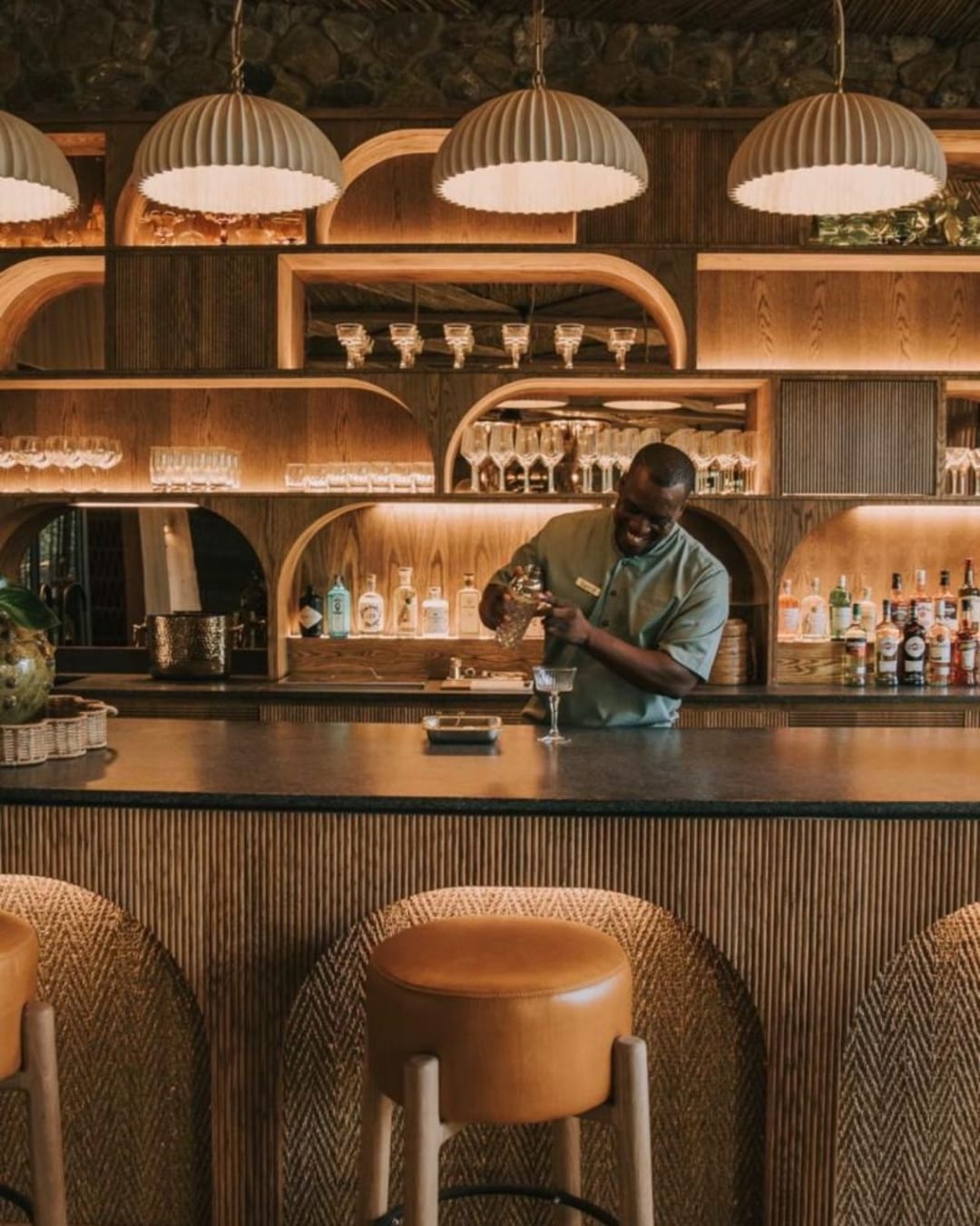 A bartender pours sundowners at a sculptural lodge bar in the Greater Kruger, the bush leg of our nine-night Cape to Kruger journey