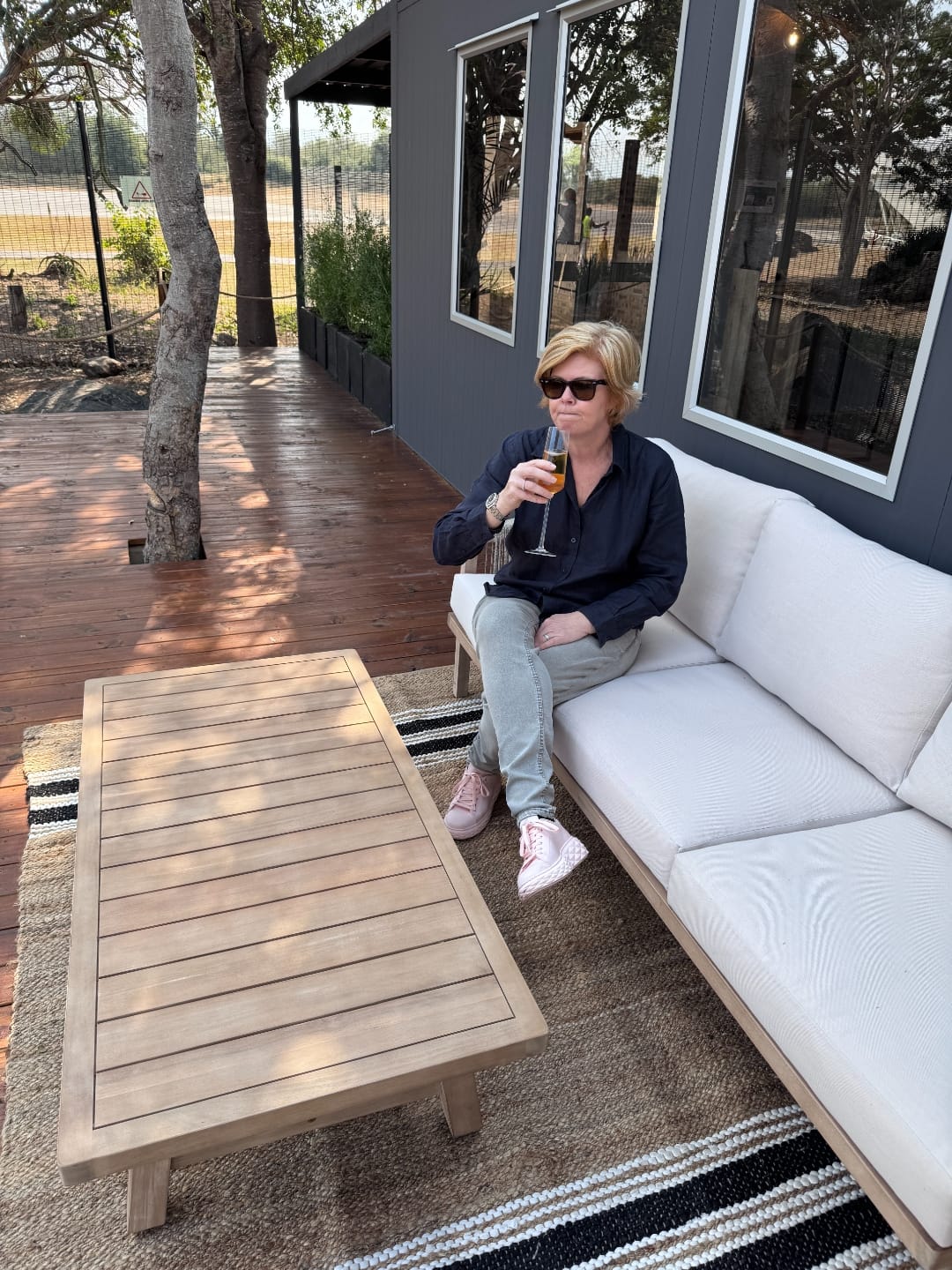 Vikki Jackson on the outdoor deck of the Baobab lounge with a glass of champagne