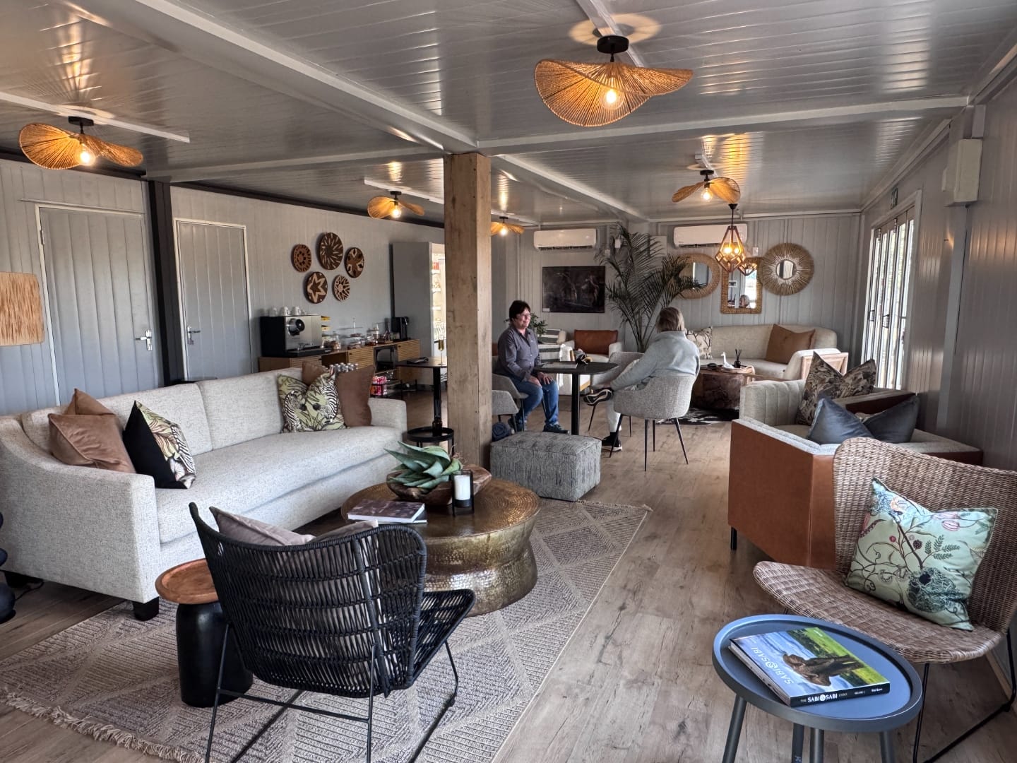 Wide view of the Baobab lounge interior with multiple seating clusters and rattan pendant shades