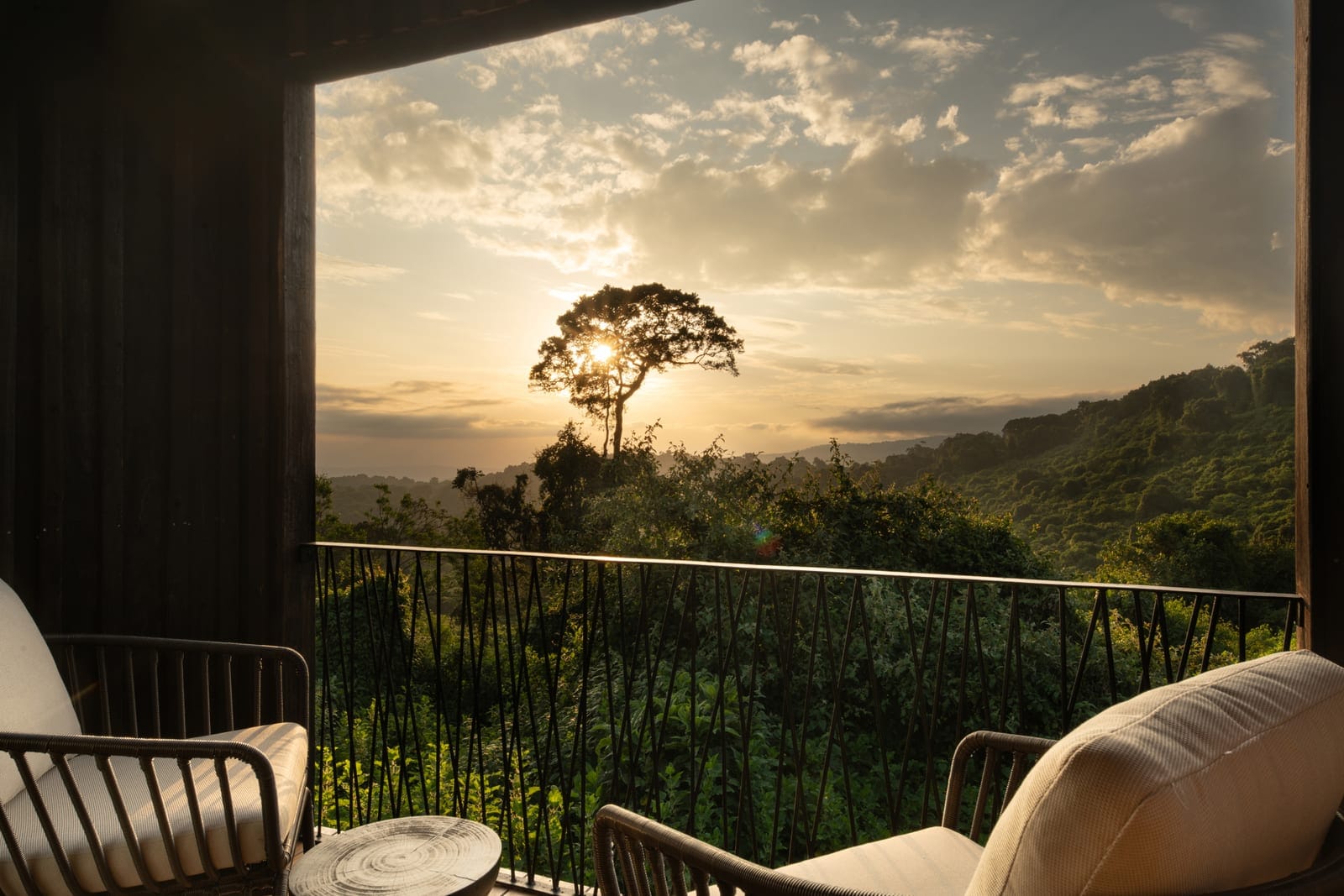 Stone-built lodge on the rim of the Ngorongoro Crater at golden hour, the caldera floor falling away below