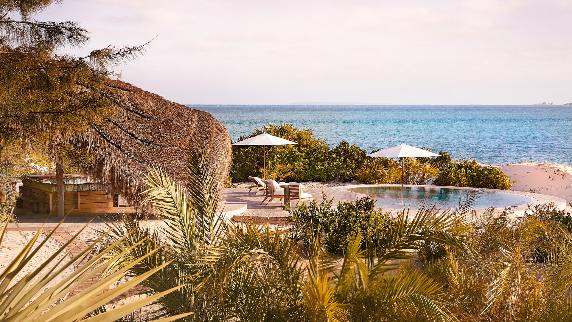 Kisawa Sanctuary pool with palms and the Indian Ocean beyond, Benguerra Island, Mozambique