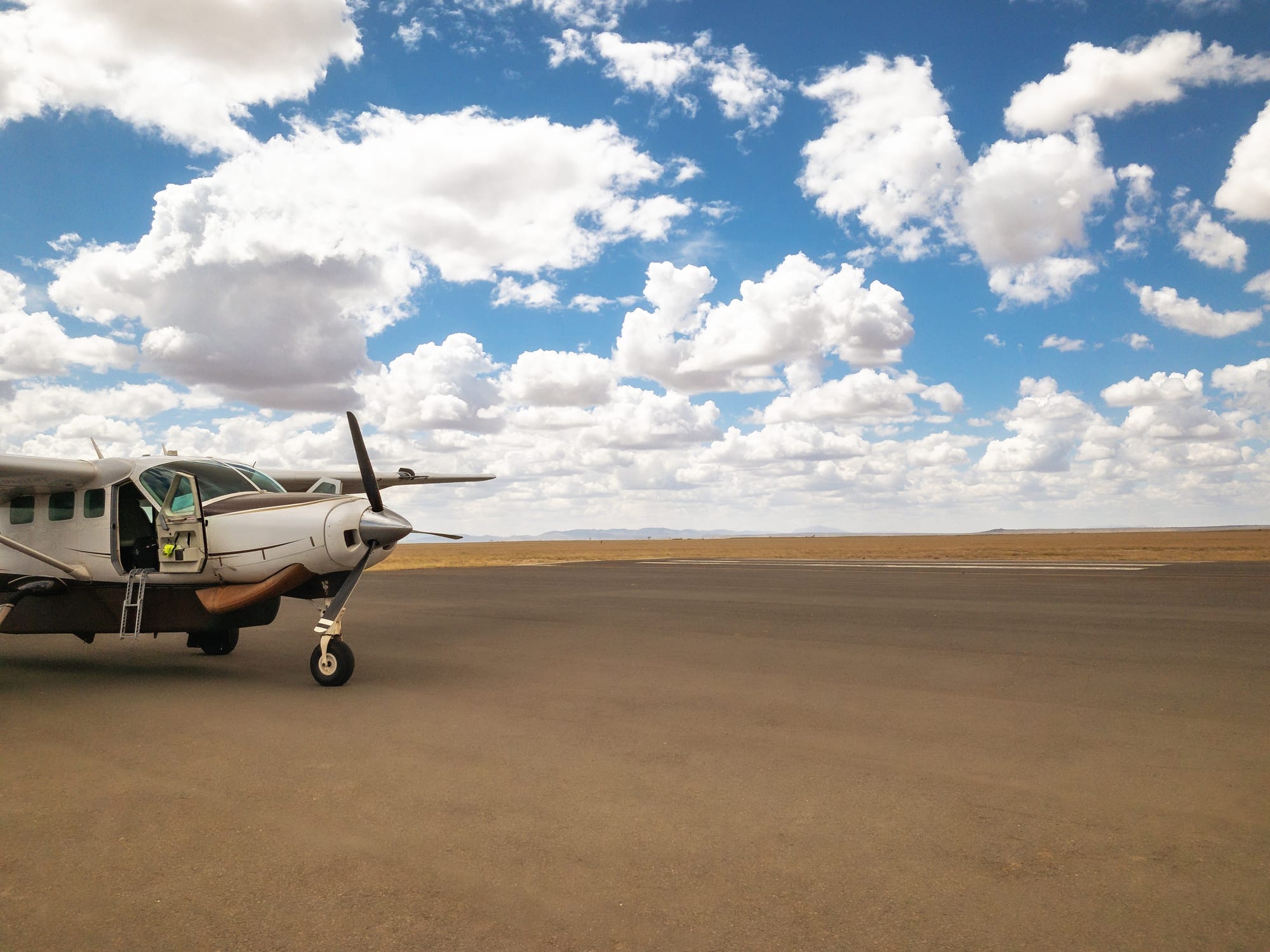 A light aircraft on a Serengeti airstrip, the fly-in network that connects Tanzania's parks to Kenya, Rwanda, and the Indian Ocean coast