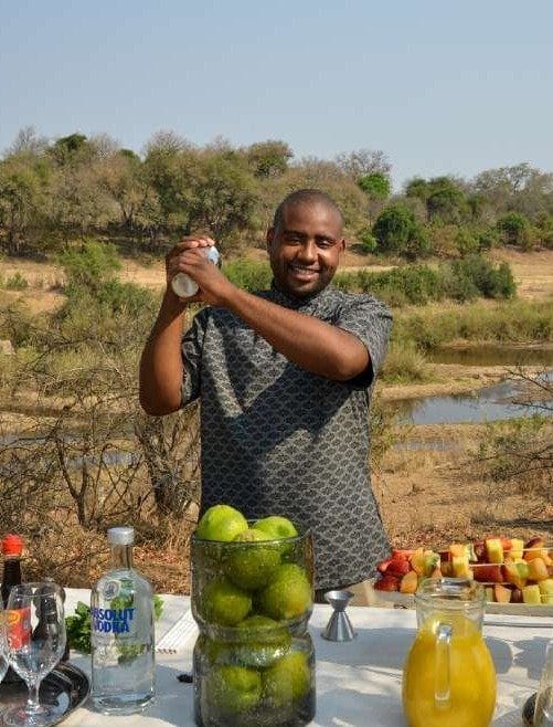 Barman preparing sundowner drinks at a bush bar on safari
