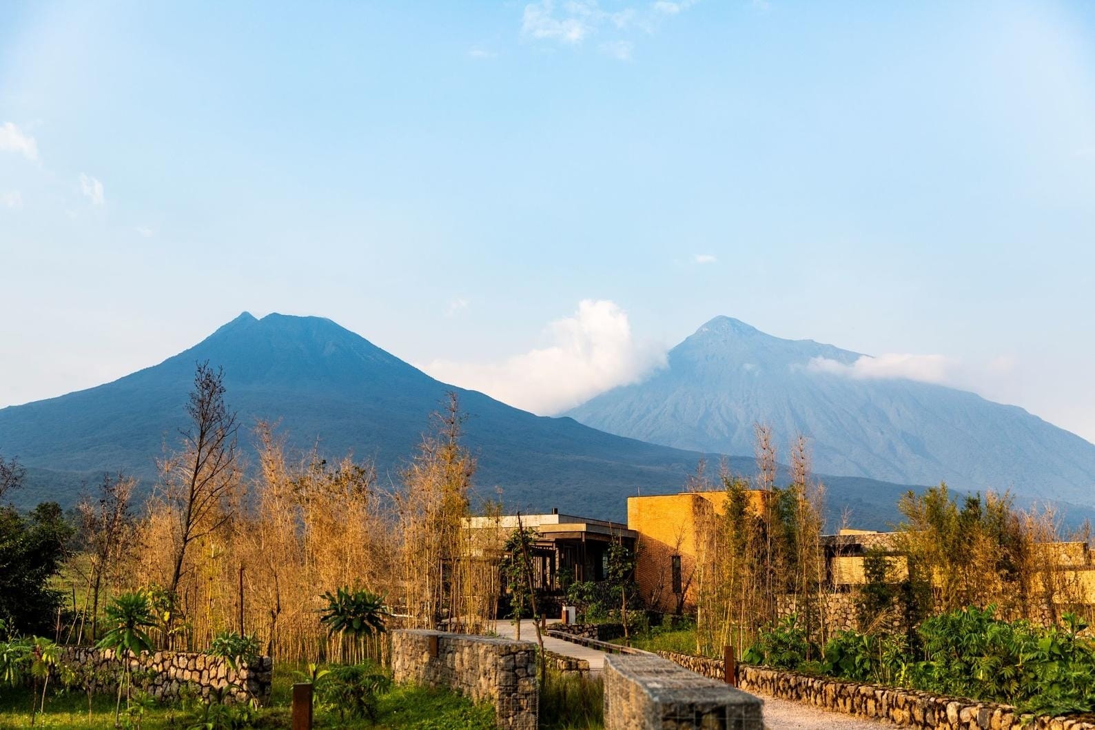 Lodge buildings below the Virunga volcanoes at sunrise, the setting for our five-night Rwanda gorilla itinerary