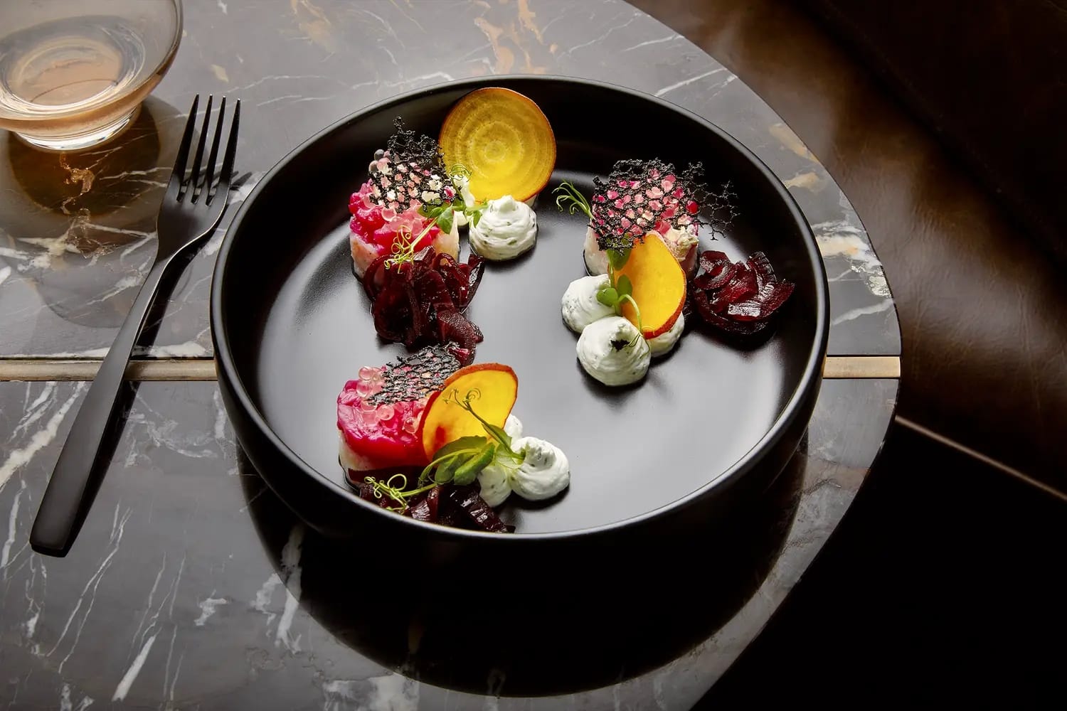 Plated beetroot and citrus starter served on a dark marble table