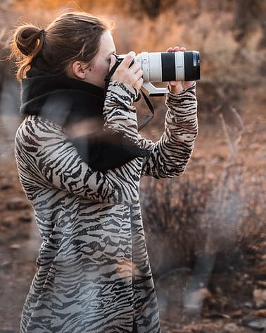 Lea Milde photographing in the field with a long lens