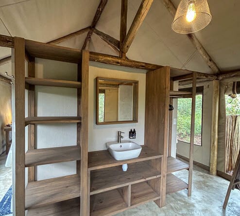 The en-suite bathroom, timber shelves and a basin under a lantern