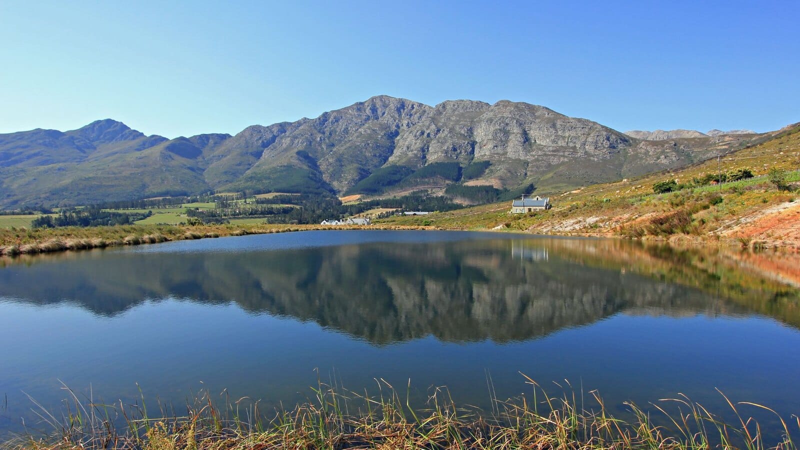 Mountains reflected in a still farm dam in the Cape Winelands