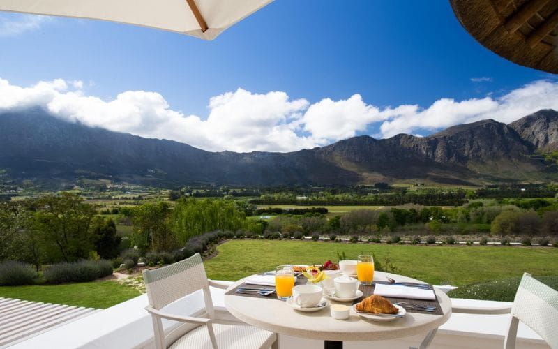Aerial view of Mont Rochelle hotel and vineyards in the Franschhoek valley with mountain backdrop