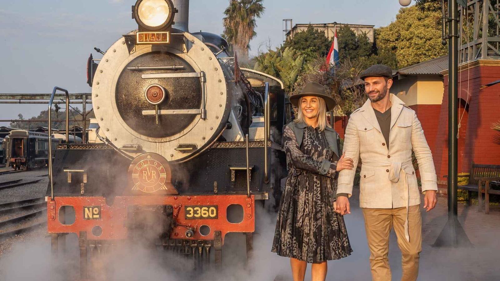 Vintage luxury train on the open observation deck rolling through African landscape at dusk