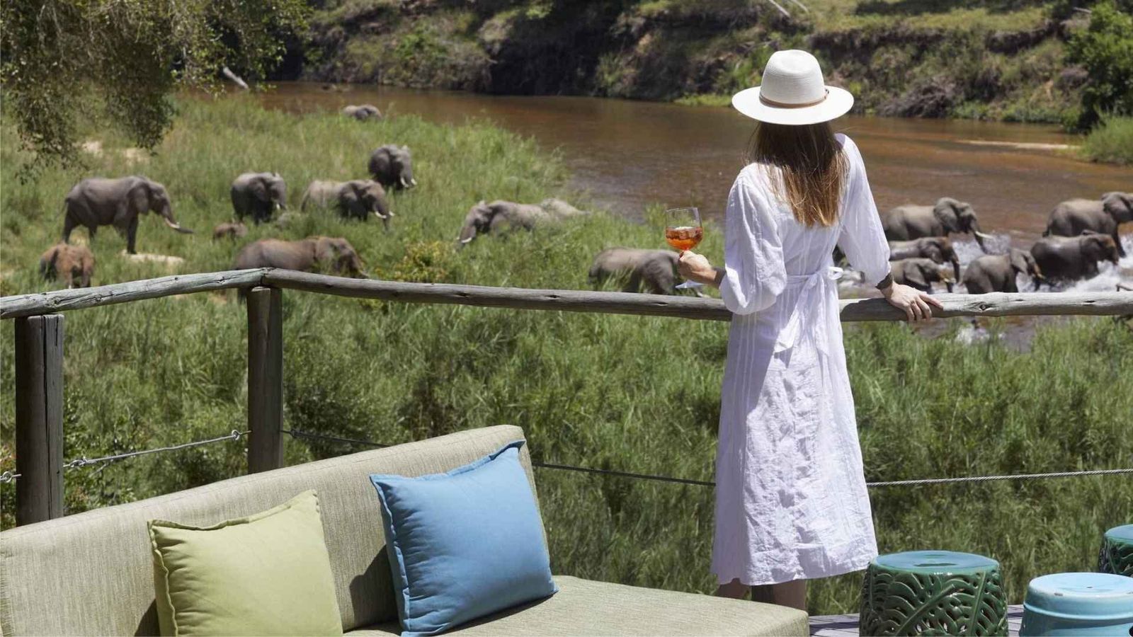 Solo traveller on a private deck at an African safari lodge at sunset